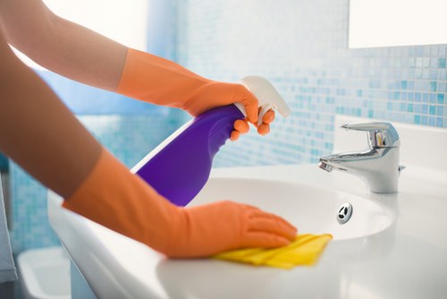 Cleaner using safe practices with equipment in a professional indoor setting