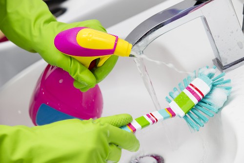Professional cleaner dusting surfaces in a West Hampstead home